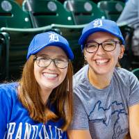 Two young GVSU students smiling in the stands of Comerica Park